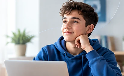 Estudante sorrindo, com a m�o no queixo, pensativo diante do notebook.